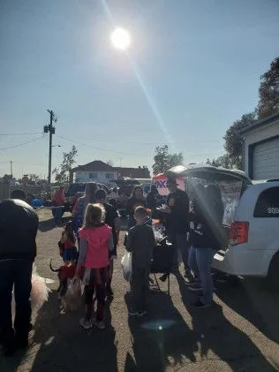 A group of people are standing in front of a white van.
