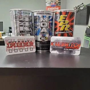 Three cans of energy drinks are sitting on top of a table.